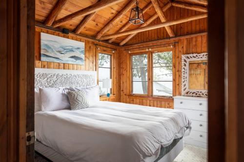 a bedroom with a white bed in a wooden room at Lee Point Classic Cabins on West Bay with Hot Tub in Suttons Bay