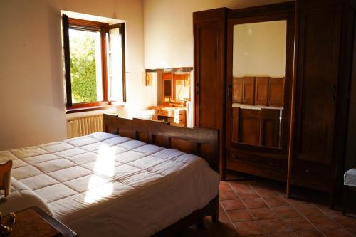 a bedroom with a large bed and a kitchen at Agriturismo Podere Luchiano in Amelia