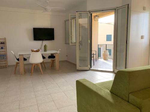 een woonkamer met een bank, een tafel en een televisie bij La Cirica in Marzamemi