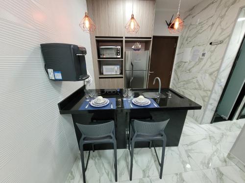 a bathroom with a counter with two chairs and a television at Angra Inn, Angra dos Reis - Mar, Sol e Piscina in Angra dos Reis