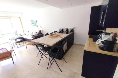 une cuisine avec une table et des chaises dans une pièce dans l'établissement WE CANNES ! Exceptional 4 rooms apartment Cannes Center swimming pool, à Cannes