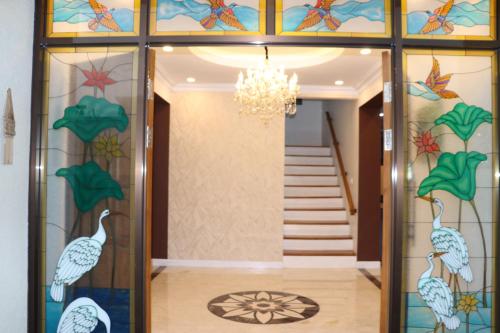 a hallway with a glass door with a chandelier at Villa Munjul Indah - Majalengka in Jatipamor