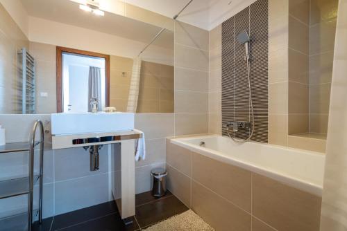 bagno con vasca e lavandino di TATRYSTAY Oliver Apartments a Štrbské Pleso