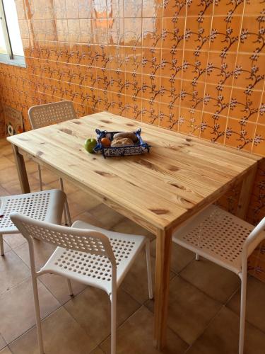 a wooden table with two white chairs and a wooden table and chairs at 10 to Ocean in Figueira da Foz