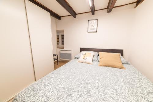 une chambre avec un lit avec deux oreillers dessus dans l'établissement Ou Mentounasc - Duplex Vieille Ville Menton - Free Parking, à Menton
