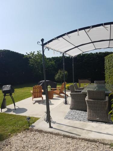 a pergola with chairs and a grill on a patio at Le pigeonnier / Gîte de charme 1 à 4 pers 80 m² in Cambrai