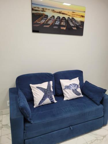 a blue couch with two star pillows on it at Angra Inn, Angra dos Reis - Mar, Sol e Piscina in Angra dos Reis