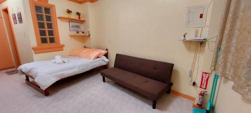um pequeno quarto com uma cama e um banco em Solar paneled home. Worry free for outages. em Bacolod