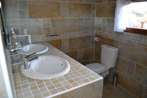 a bathroom with two sinks and a toilet at a Casa in Calenzana