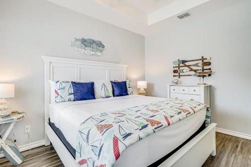 a bedroom with a large white bed with blue pillows at Carpe BeachBum in Port Aransas