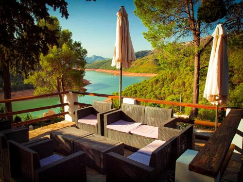 a patio with an umbrella and chairs and a table at Casa Rural Los Parrales in El Tranco