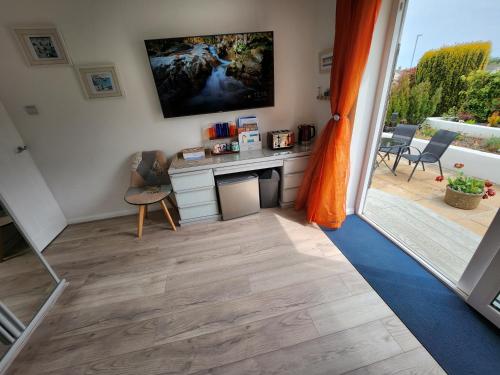 a room with a kitchen with a view of a patio at Seaspot is a 1 bed annex ground floor apartment at stunning Broadsands Beach nr Brixham! in Churston Ferrers
