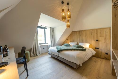 een slaapkamer met een groot bed op zolder bij Wood (Forestia) in Theux