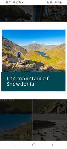 a screenshot of the mountain of snowdonia with a man standing on a hill at Sunny49 min 3 night stay in Caeathro