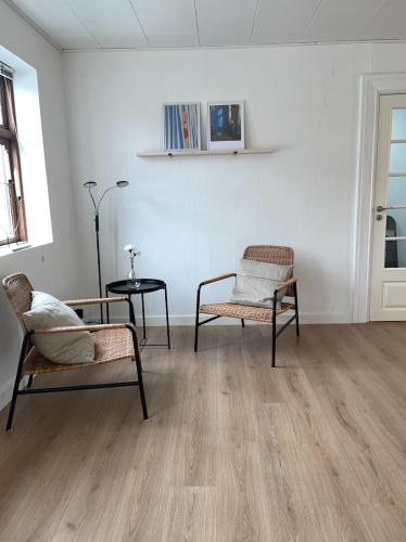 a living room with two chairs and a table at Hyggeligt sommerhus i Jerup in Jerup