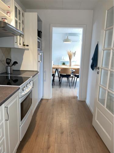 a kitchen with a dining room with a table at Hyggeligt sommerhus i Jerup in Jerup