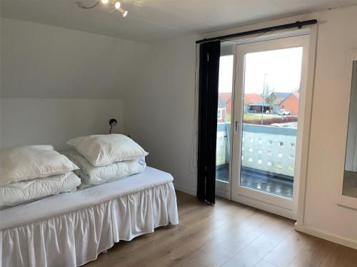 a bedroom with a bed and a sliding glass door at Hyggeligt sommerhus i Jerup in Jerup