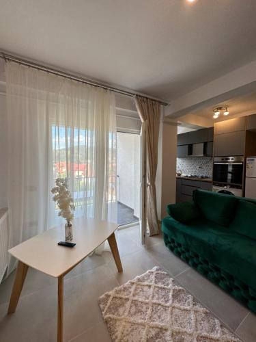 un soggiorno con divano verde e tavolo di Apartamente Ariniș a Gura Humorului
