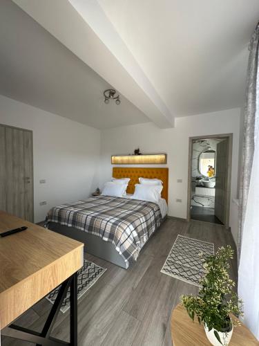 a bedroom with a bed with a wooden headboard at Apartamente Ariniș in Gura Humorului