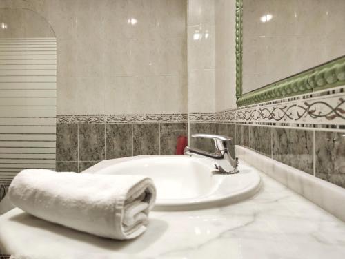 a bathroom with a sink with a towel on it at Desconectaengalicia Ático La Lanzada in A Lanzada