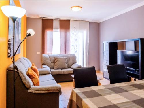 a living room with a couch and a television at Live Puertito Almirante in Puertito de Güímar