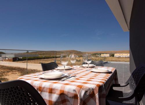 a table with wine glasses and a view of the desert at Sunset House in Vila do Bispo