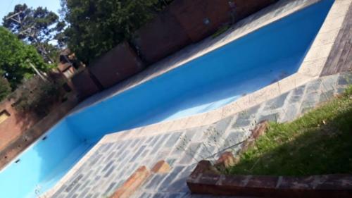 una persona que toma una foto de una piscina en Casa en Pinamar en Pinamar