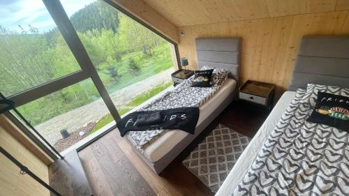 twee bedden in een kamer met een raam bij Slow Life Pod Babią Górą in Zawoja