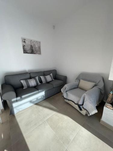 a living room with a couch and a chair at Μοντέρνα εξοχική μονοκατοικία με ιδιωτική πισίνα! in Khalkoútsion