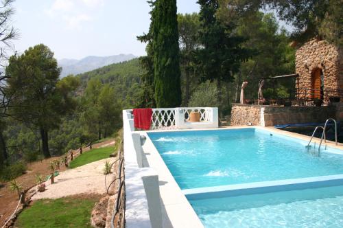 a swimming pool in front of a house at Casa Rural Los Parrales in El Tranco