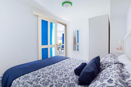 a bedroom with a bed with blue and white sheets at Casa Vacanza Verde Smeraldo- (San Montano) in Massa Lubrense