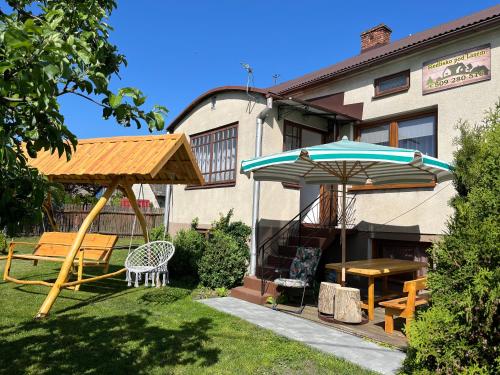a patio with a table and an umbrella at Siedlisko pod Lasem in Józefów