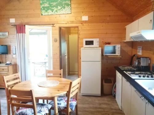 eine Küche mit einem Tisch und Stühlen in einer Hütte in der Unterkunft Le Chalet de Lilie in Bassignac