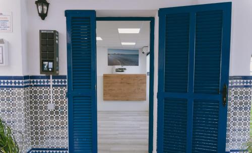 eine blaue Tür, die zu einem Bad mit einem Waschbecken führt in der Unterkunft P Cormoran 3255 in La Manga del Mar Menor