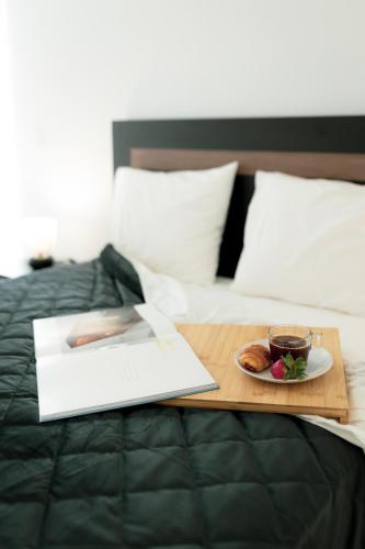 a tray with a cup of tea and a plate of food on a bed at Gold Apartment Ferrel II in Ferrel