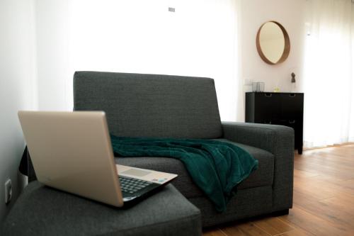a laptop computer sitting on a couch in a living room at Gold Apartment Ferrel II in Ferrel