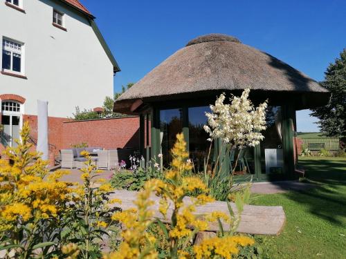 a gazebo in a garden with yellow flowers at Landtraum im Traumland Mecklenburg in Warin