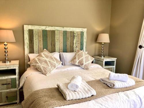 una camera da letto con un letto con asciugamani sopra di Riverlea Farm Self-Catering Unit a George