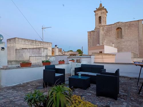 patio z krzesłami i stołami na dachu budynku w obiekcie Casa vacanze Chiarodiluna w mieście Giurdignano