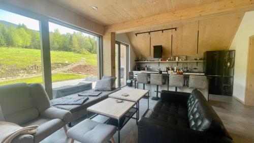Una sala de estar con un sofá y una cocina. en Slow Life Pod Babią Górą, en Zawoja