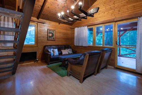 una sala de estar con sofá y sillas en una cabaña en TATRYSTAY Chalet Kristina en Demanovska Dolina