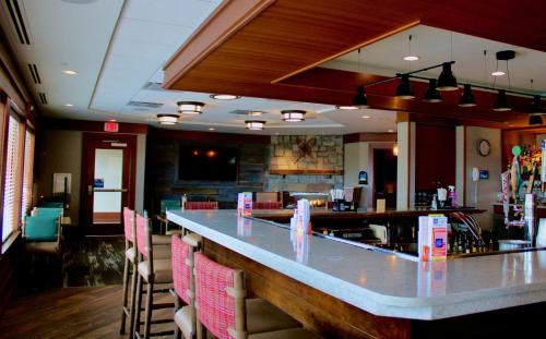 a bar in a restaurant with chairs and a counter at Holiday Inn Resort Lake George by IHG in Lake George