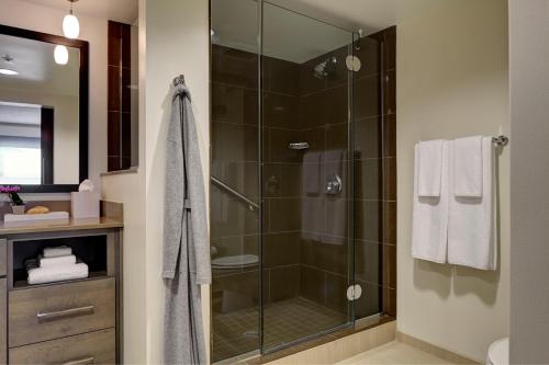 um chuveiro com uma porta de vidro na casa de banho em Hyatt Place Sacramento International Airport em Sacramento
