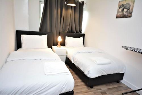 two beds sitting next to each other in a room at Lovely 2 bed Flat in S/E London in Abbey Wood