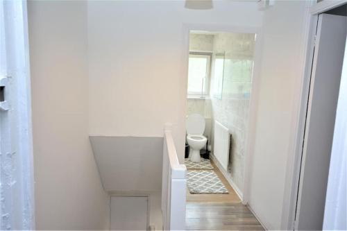 a white bathroom with a toilet in a room at Lovely 2 bed Flat in S/E London in Abbey Wood