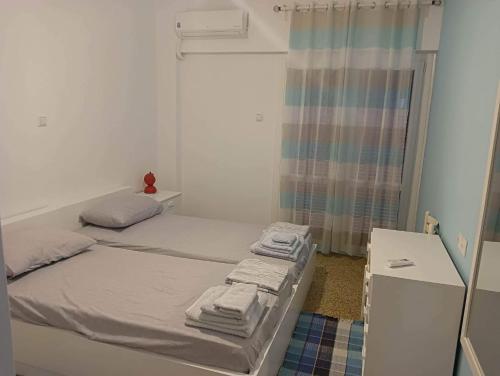 ein kleines Schlafzimmer mit 2 Betten und einem Fenster in der Unterkunft Apartment with sea view in Oropos
