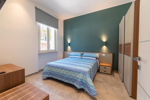 a bedroom with a bed and a blue wall at Villa Gina Case Vacanze in Roseto degli Abruzzi
