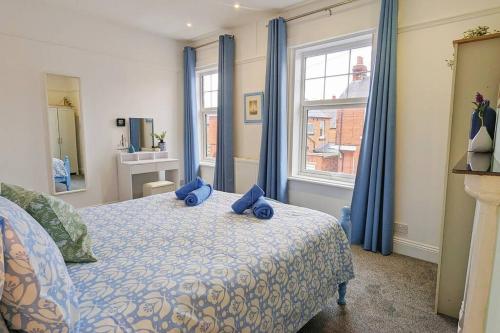 een slaapkamer met een bed met blauwe kussens erop bij Seaside Escapes - with relaxing hot tub! in Scarborough
