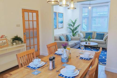 a dining room with a table and chairs and a living room at Seaside Escapes - with relaxing hot tub! in Scarborough