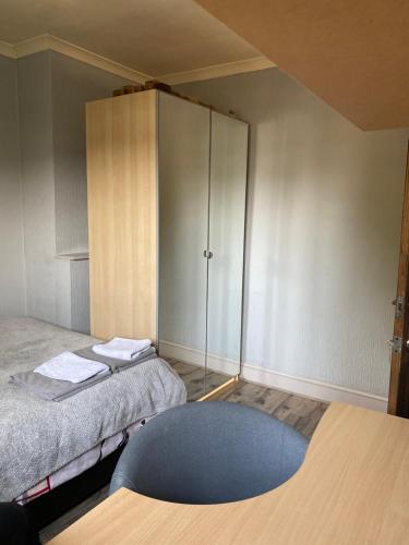 a room with two beds and a cabinet at Cosy room in cul de sac location’s home in Dagenham